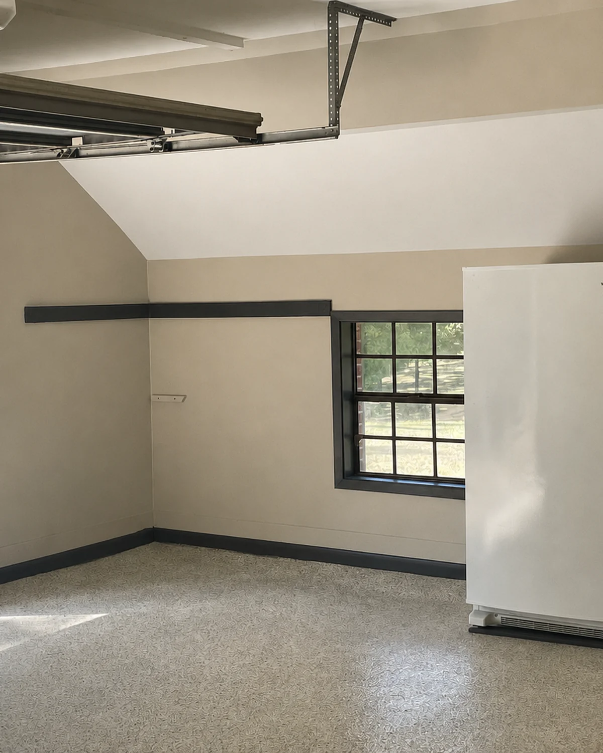 Finished garage alcove with painted walls and a light textured floor