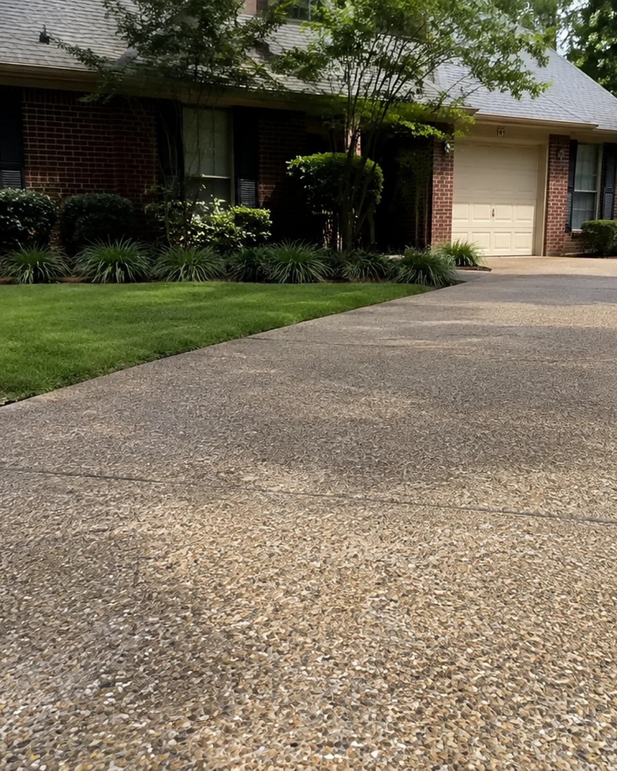 Natural stone texture along an aggregate driveway beside a lawn