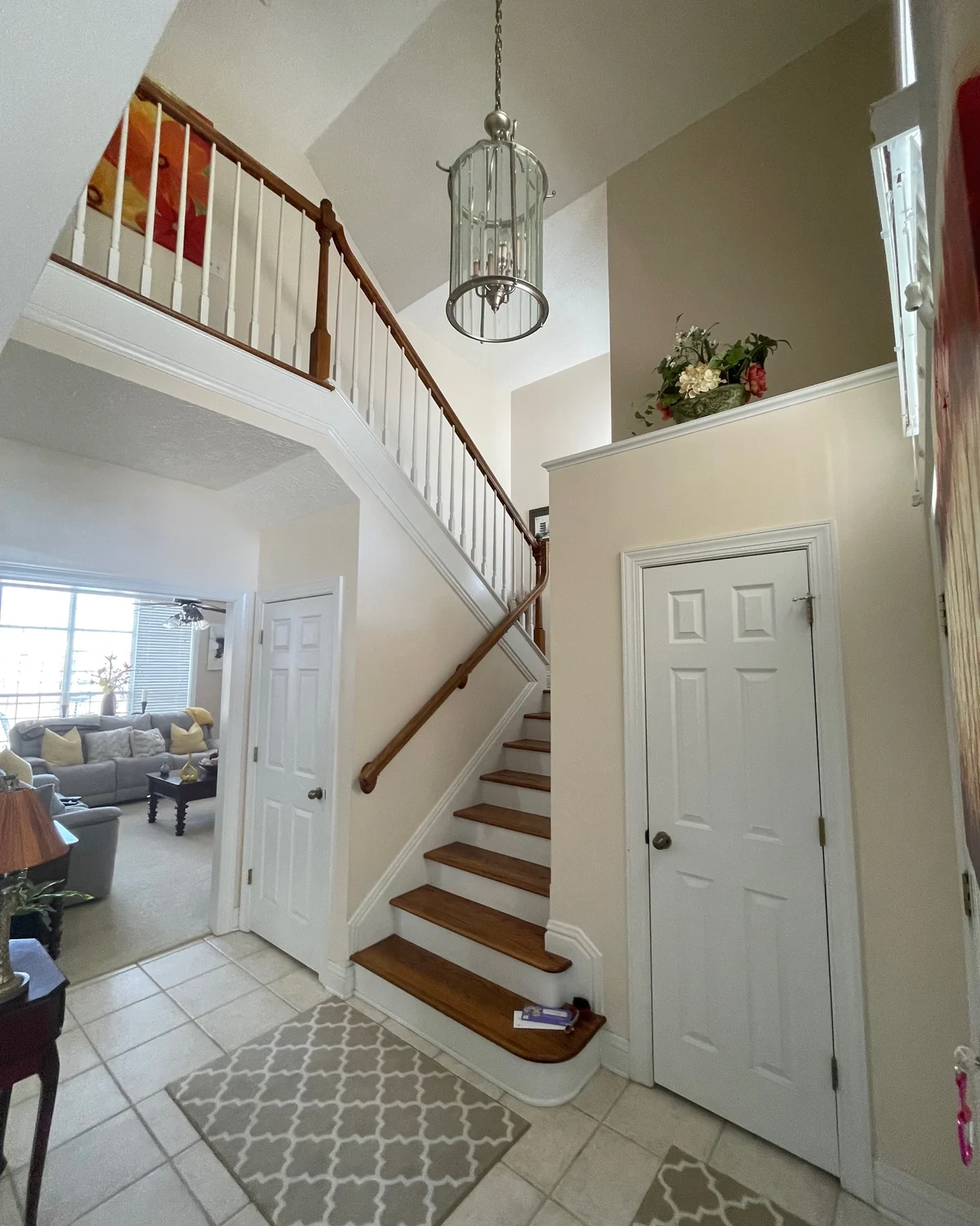 Light painted stair hall with white trim and wooden stair treads