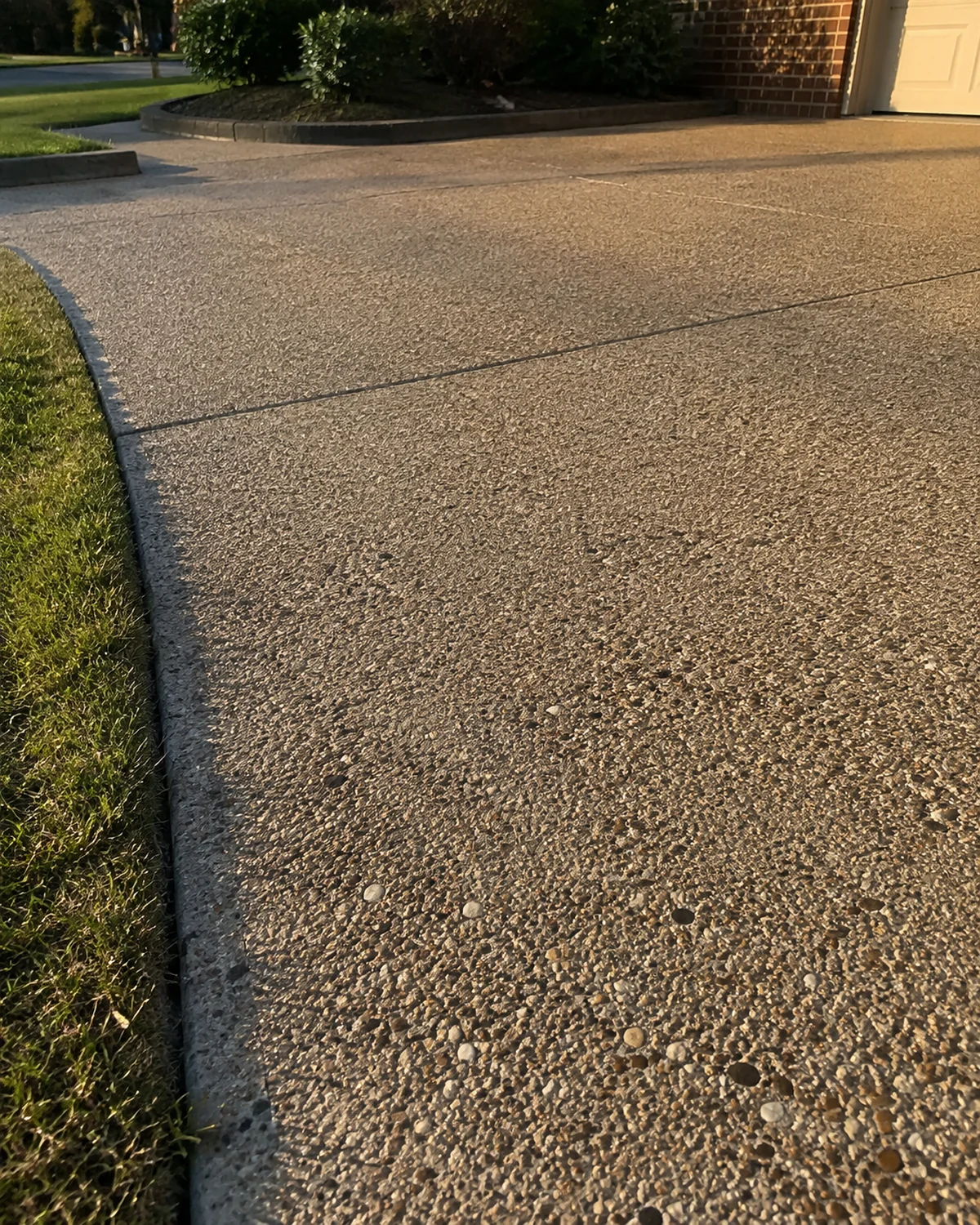 Embedded natural stones and a joint at the edge of an aggregate driveway