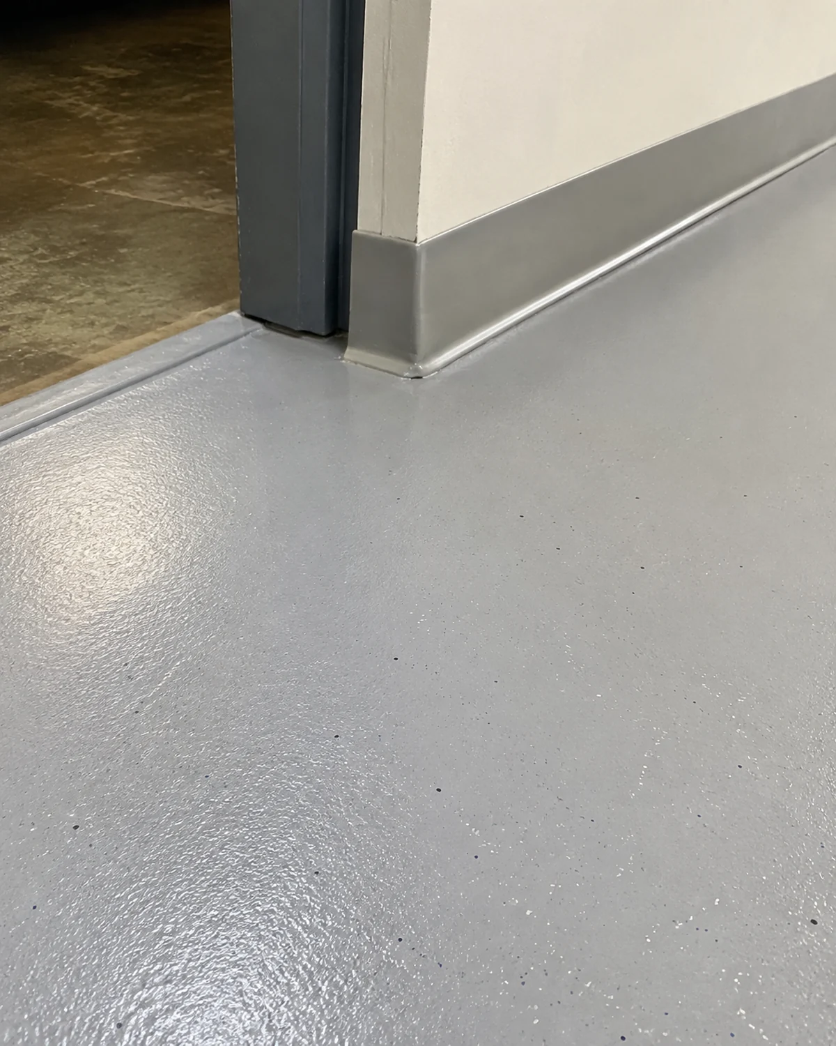Gray coated commercial floor beside a doorway