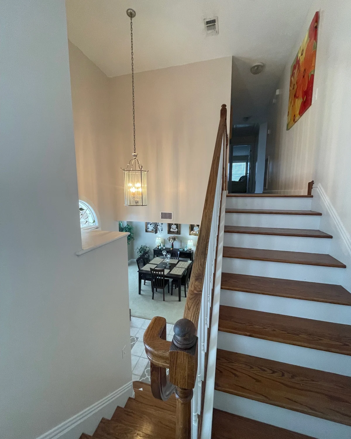Painted stair hall with white balusters and wood stair treads